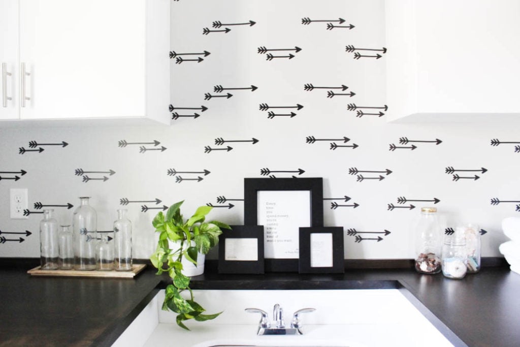 Laundry room decor featuring a faux arrow wallpaper accent wall.