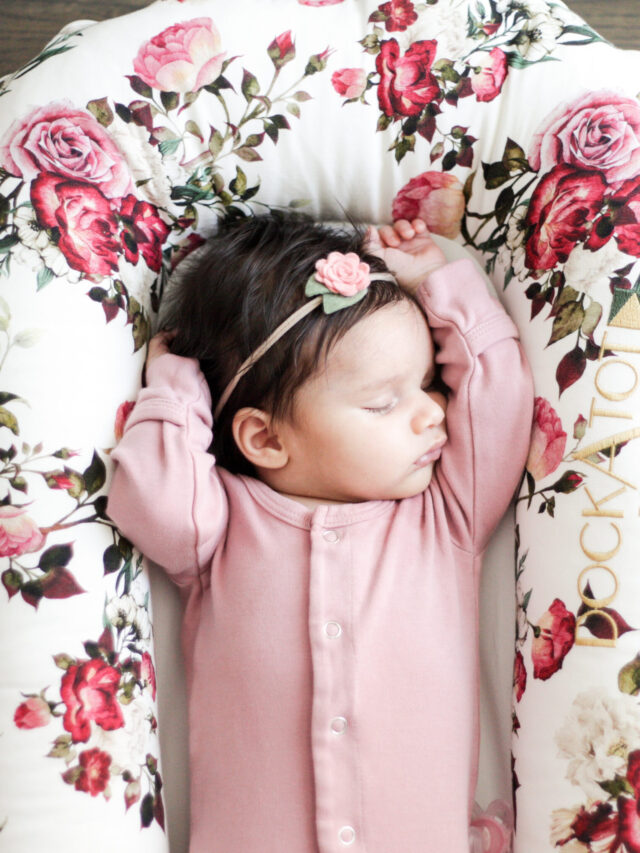Newborn baby girl sleeping in a floral dockatot deluxe.