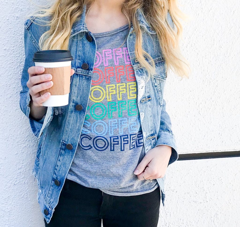 Casual travel outfit - coffee graphic tee, distressed denim jacket and black denim.