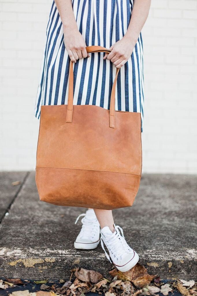 Woman holding a leather tote bag