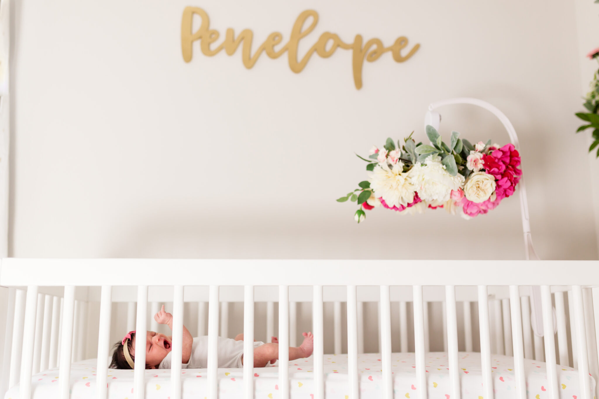 Penelope name out of wood in nursery with floral mobile