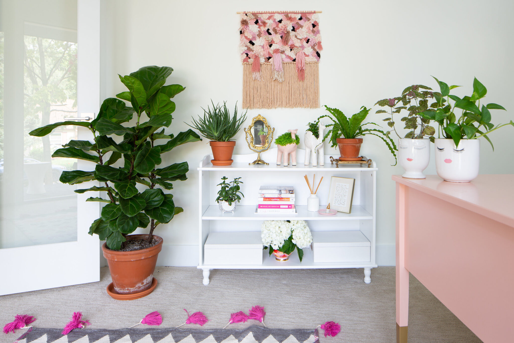 feminine home office with weave, fiddle leaf fig plant and pink accents