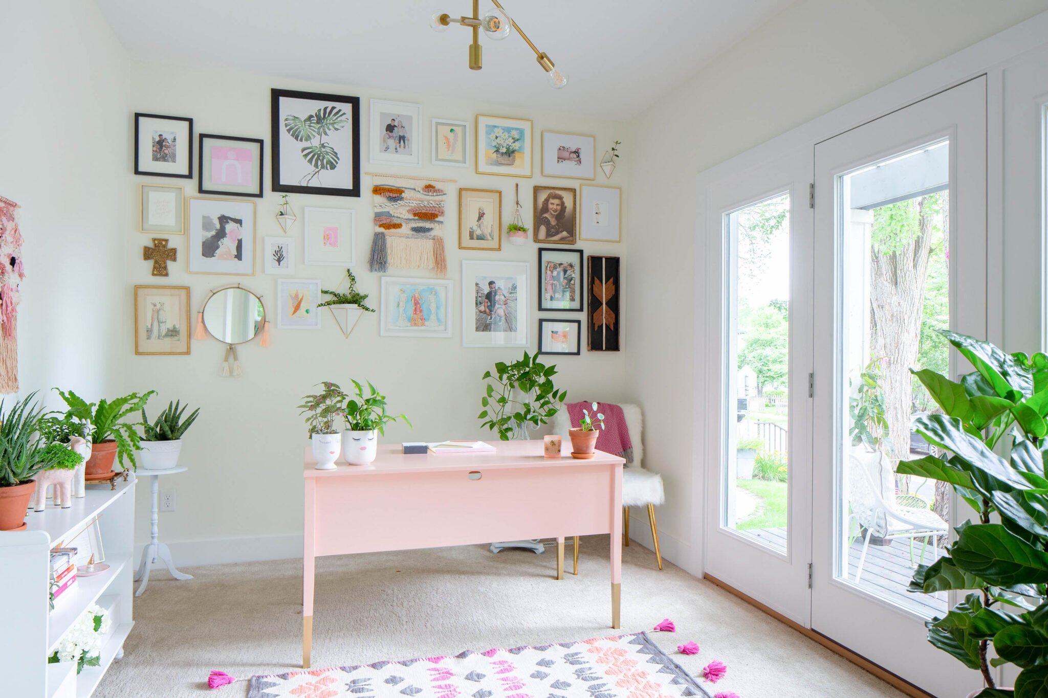 Feminine home office with pink desk and gallery wall