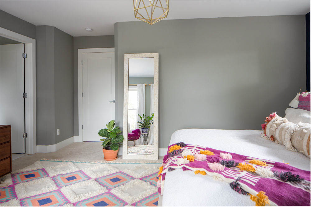 Bright master bedroom with West Elm mirror and fiddle leaf fig