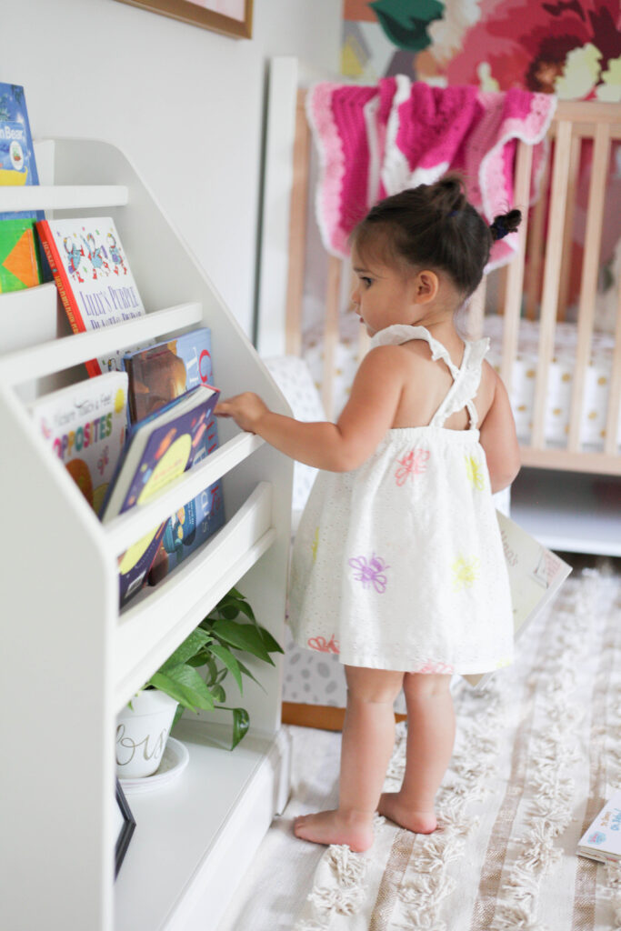 Toddler choosing books from bookshelf