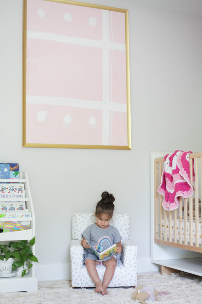 Toddler in toddler-size armchair with big Brooke & Lou framed print