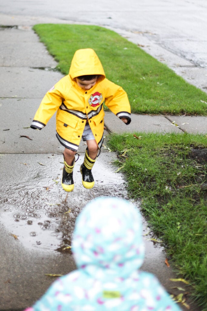 Little boy jumping in puddles.