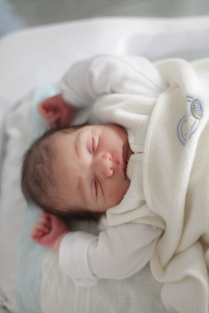 Newborn baby swaddled in halo swaddle.