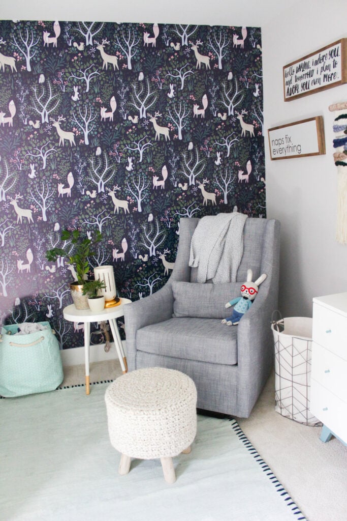 Nursery with forest pattern wallpaper on one wall