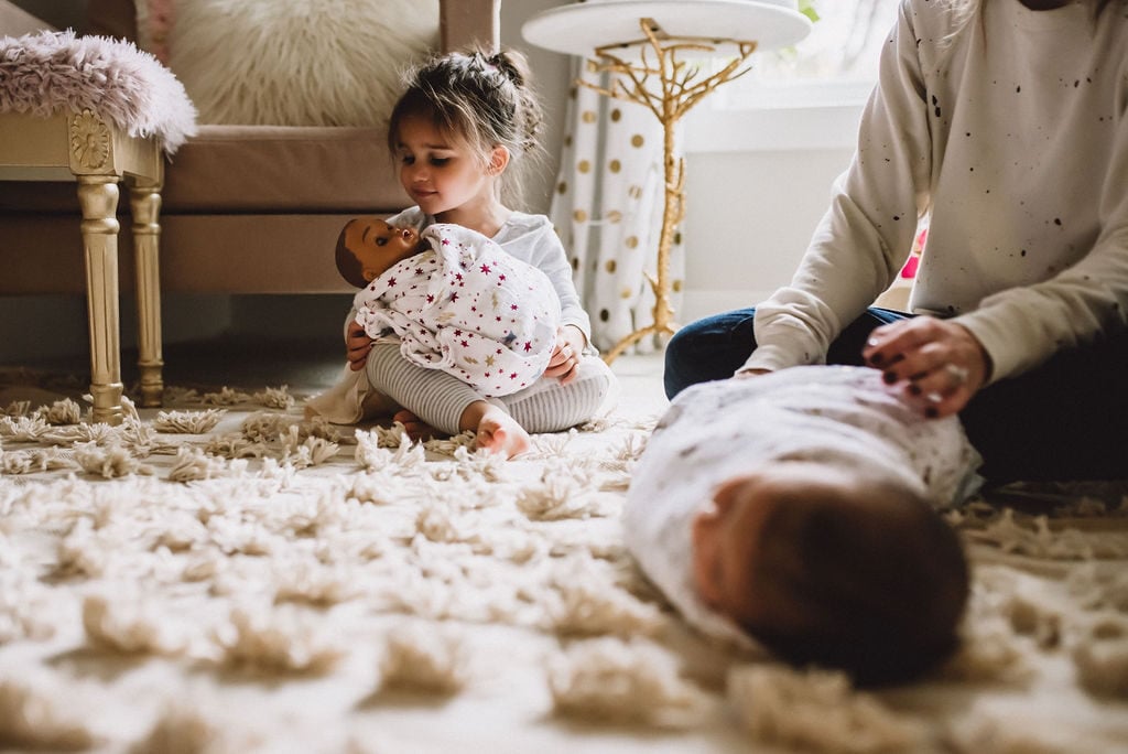 Mom and daughter wrapping up babies in aden + anais swaddle blankets.