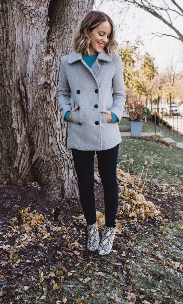 Woman in pea coat, dark jeans and snake skin boots