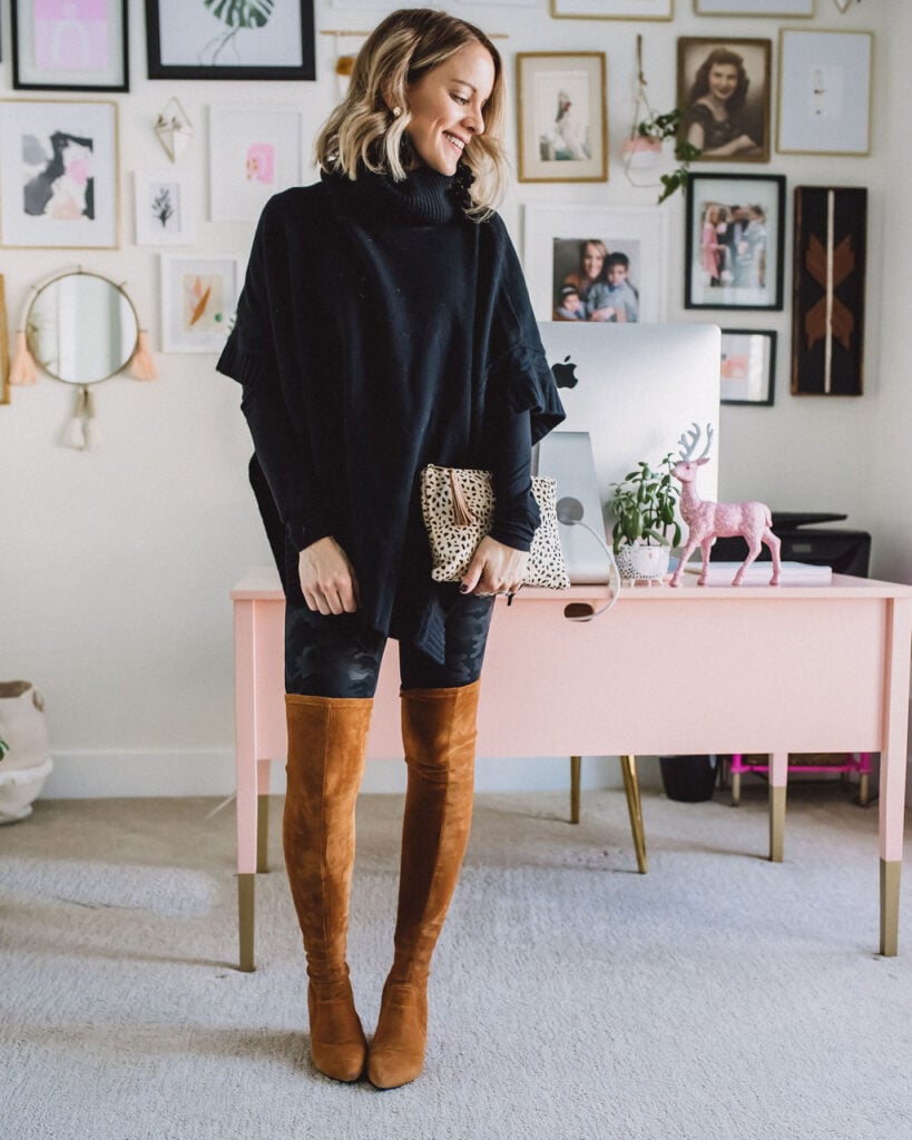 Tan over the knee boots with black poncho and leopard clutch.