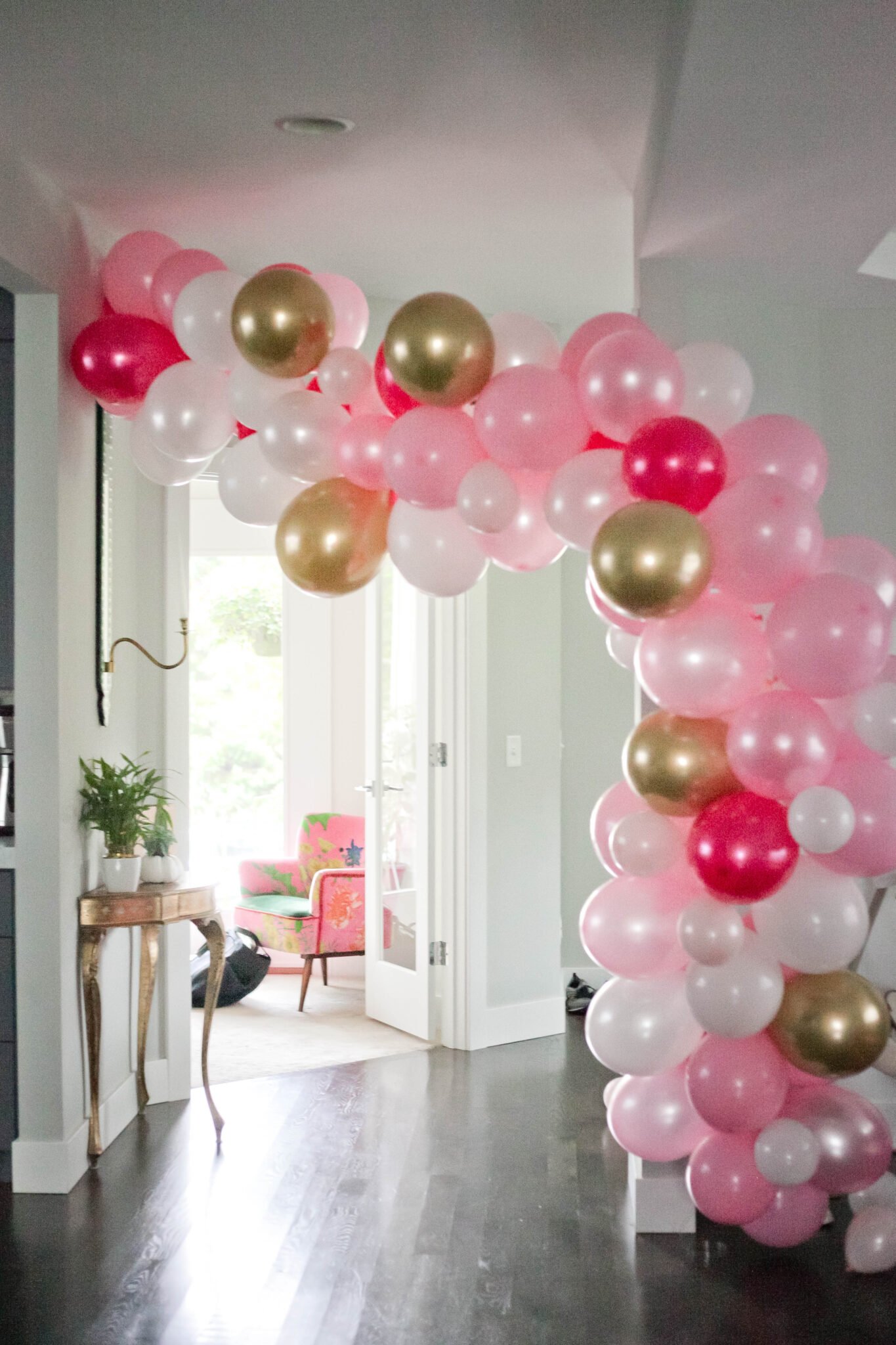 A pink, white and gold balloon arch for a Minnie Mouse birthday for a 2 year old.