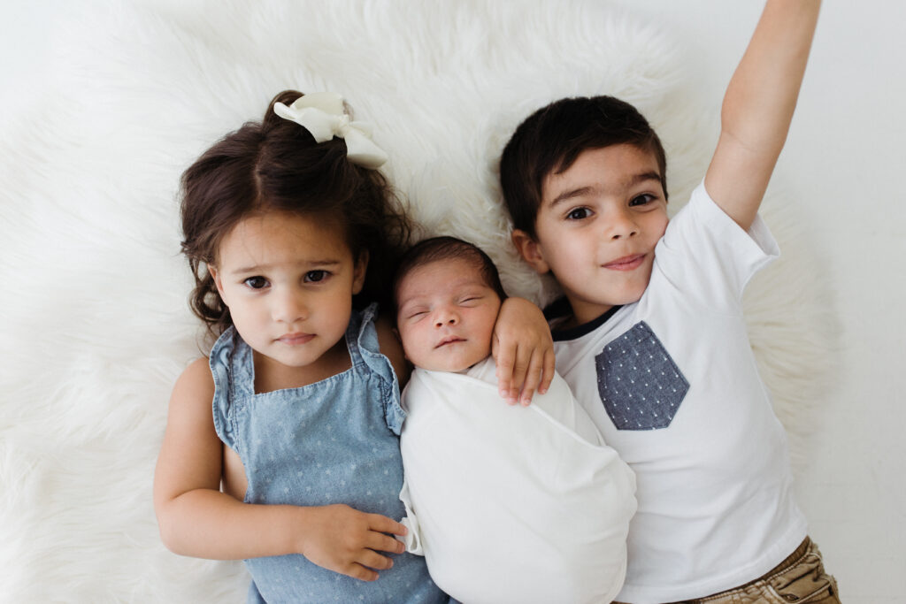 Two siblings with a newborn