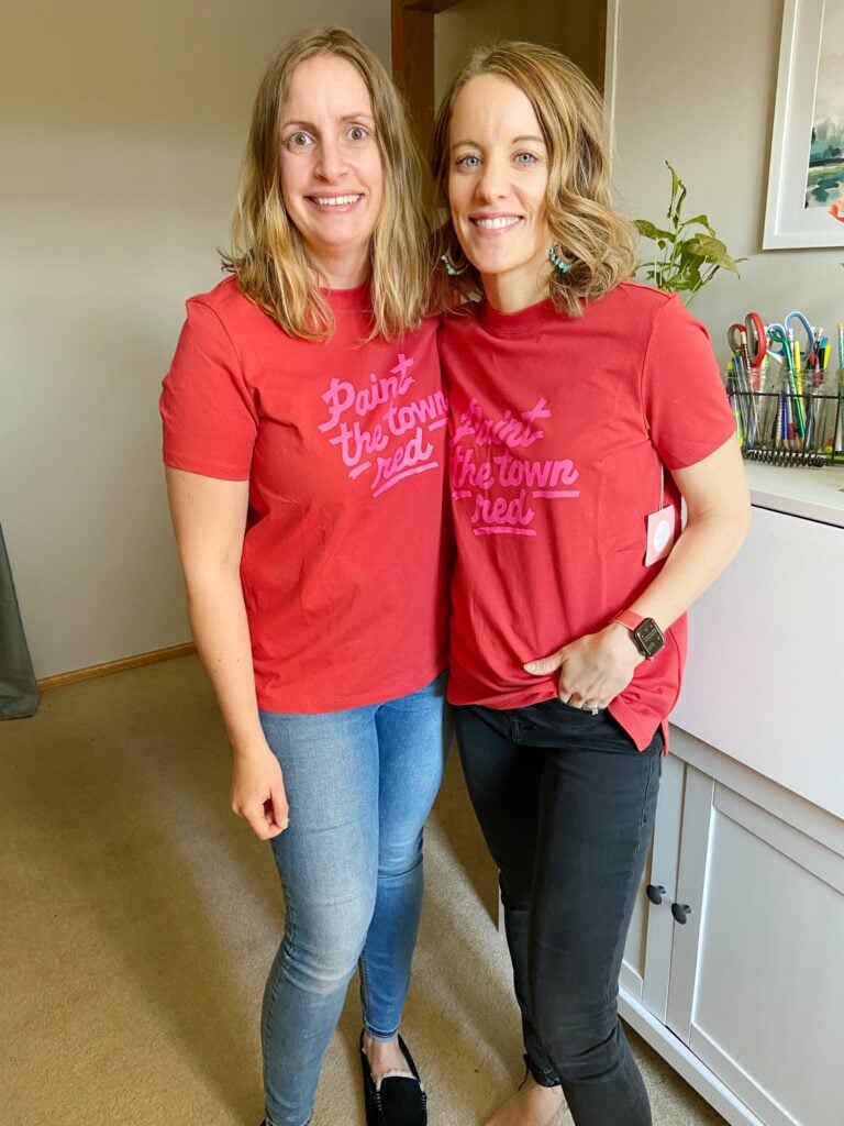 Two women wearing Paint the Town Red tee