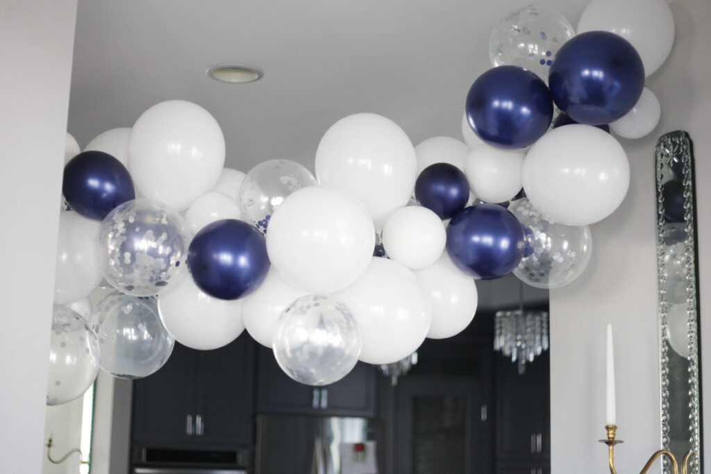 Navy, white and silver confetti balloon garland hanging in a hall