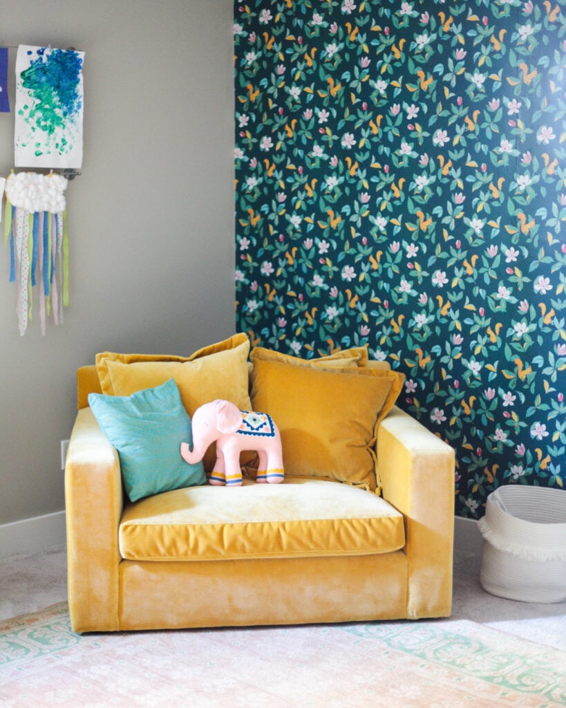 Playroom with oversized chair and floral wallpaper