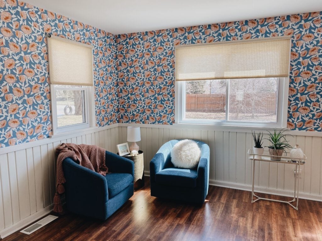 Room with floral wallpaper above beadboard