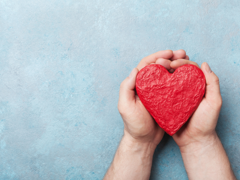 Hands holding a clay heart