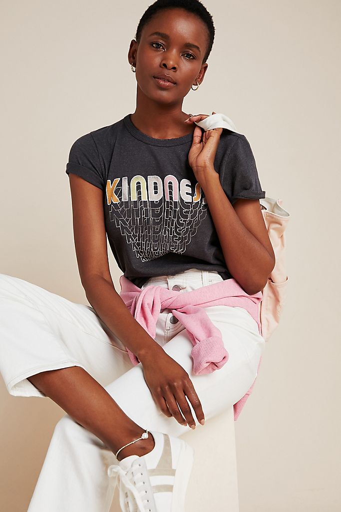 Woman wearing Anthropologie Kindness tee and white pants