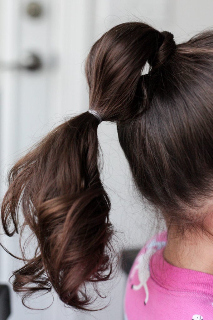 start of a bubble ponytail with elastic wrap on hair