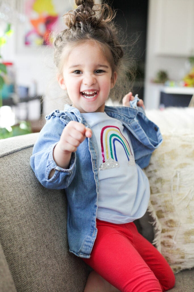 Girl wearing sequin rainbow shirt with denim jacket