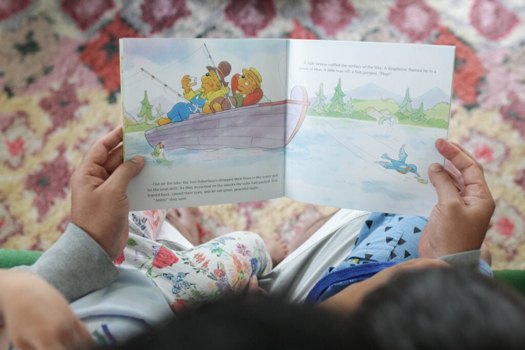 Man reading Berenstain Bears Father's Day Blessings to two kids