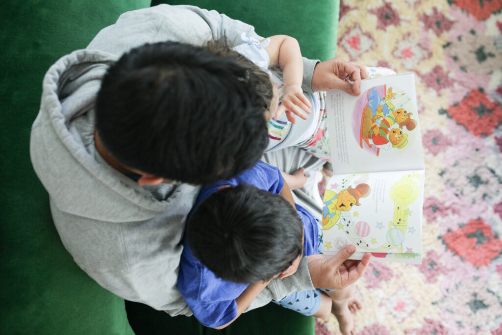 Man reading Berenstain Bears Father's Day Blessings to two kids