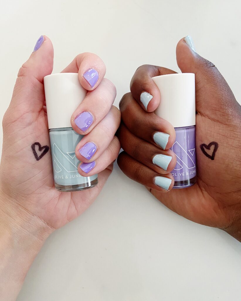 2 girls with coordinating manicures with hearts on their hand