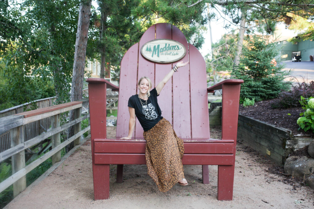 Woman in giant Adirondack chair at Madden's on Gull Lake