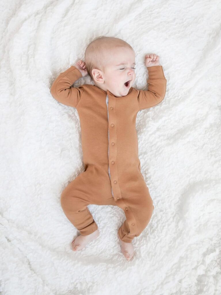 Baby in tan snap pajamas