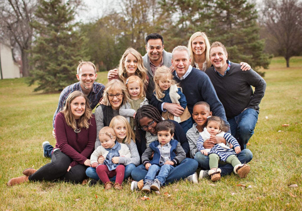 Big family in coordinating clothes with neutrals and maroon as an accent color