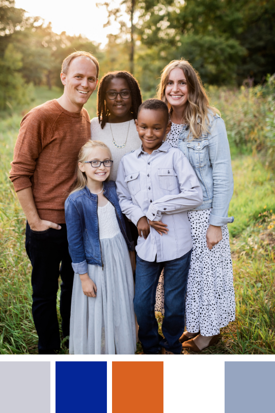 Family in coordinating outfits in a gray, blue, orange and white palette