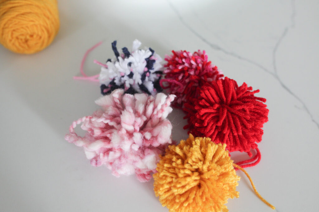 Pom poms of different colors and yarn thickness