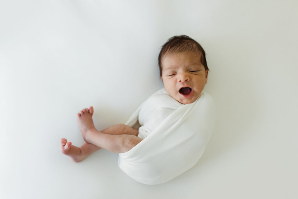 Newborn in white swaddle