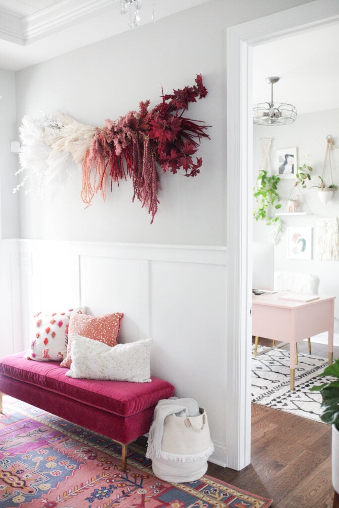 an entryway with up an ombre flower wall hanging