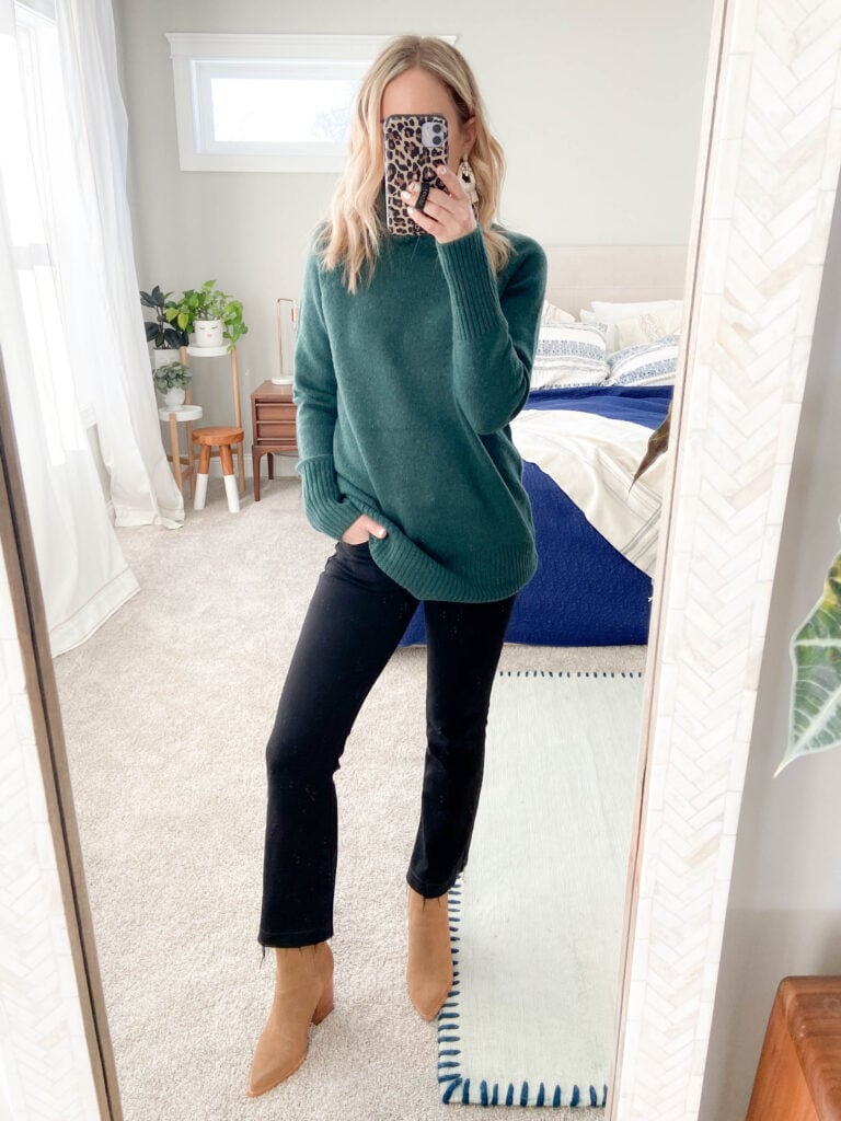 woman in oversized green sweater, black jeans and booties