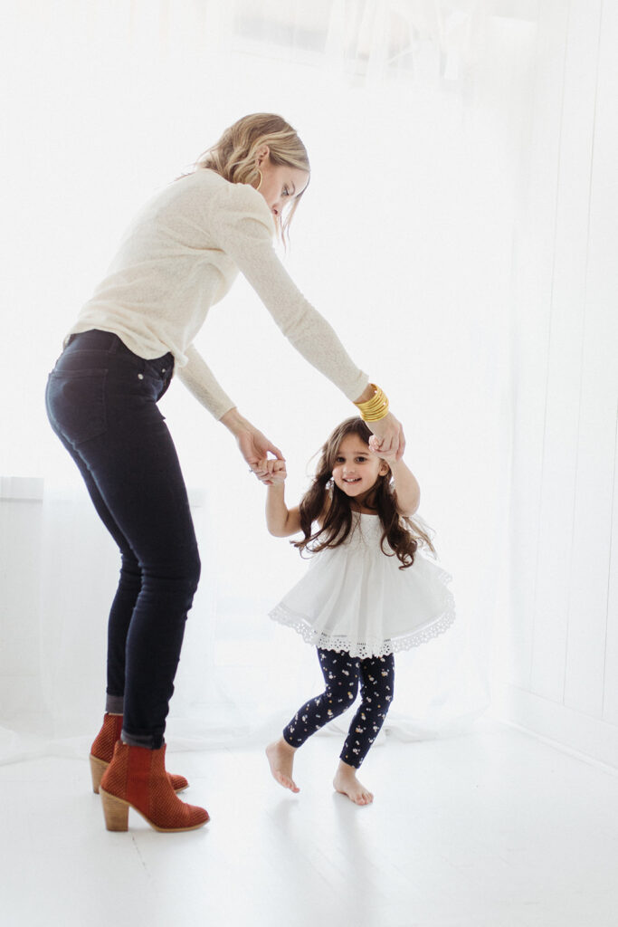 Mom and girl twirling in white clothes