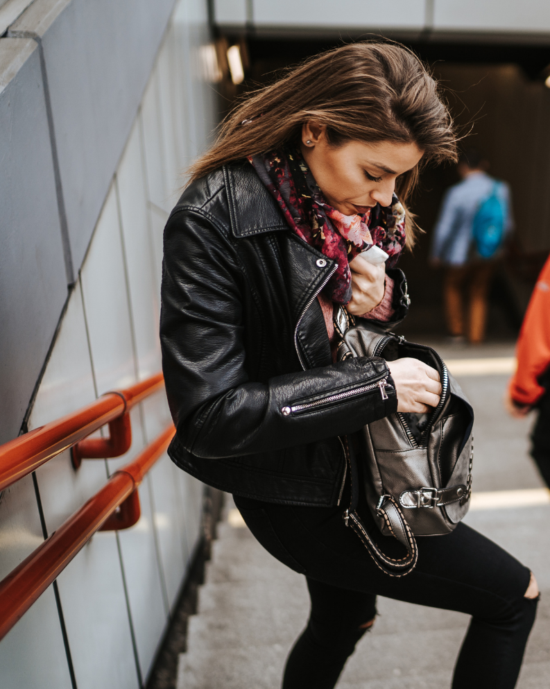 Woman looking through her leather backpack