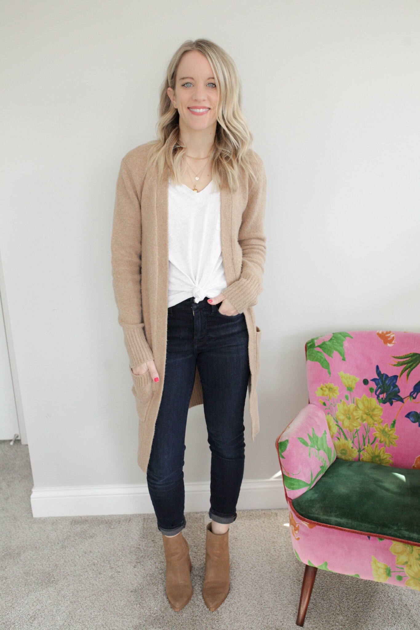 woman in white tshirt, long cardigan, jeans and boots