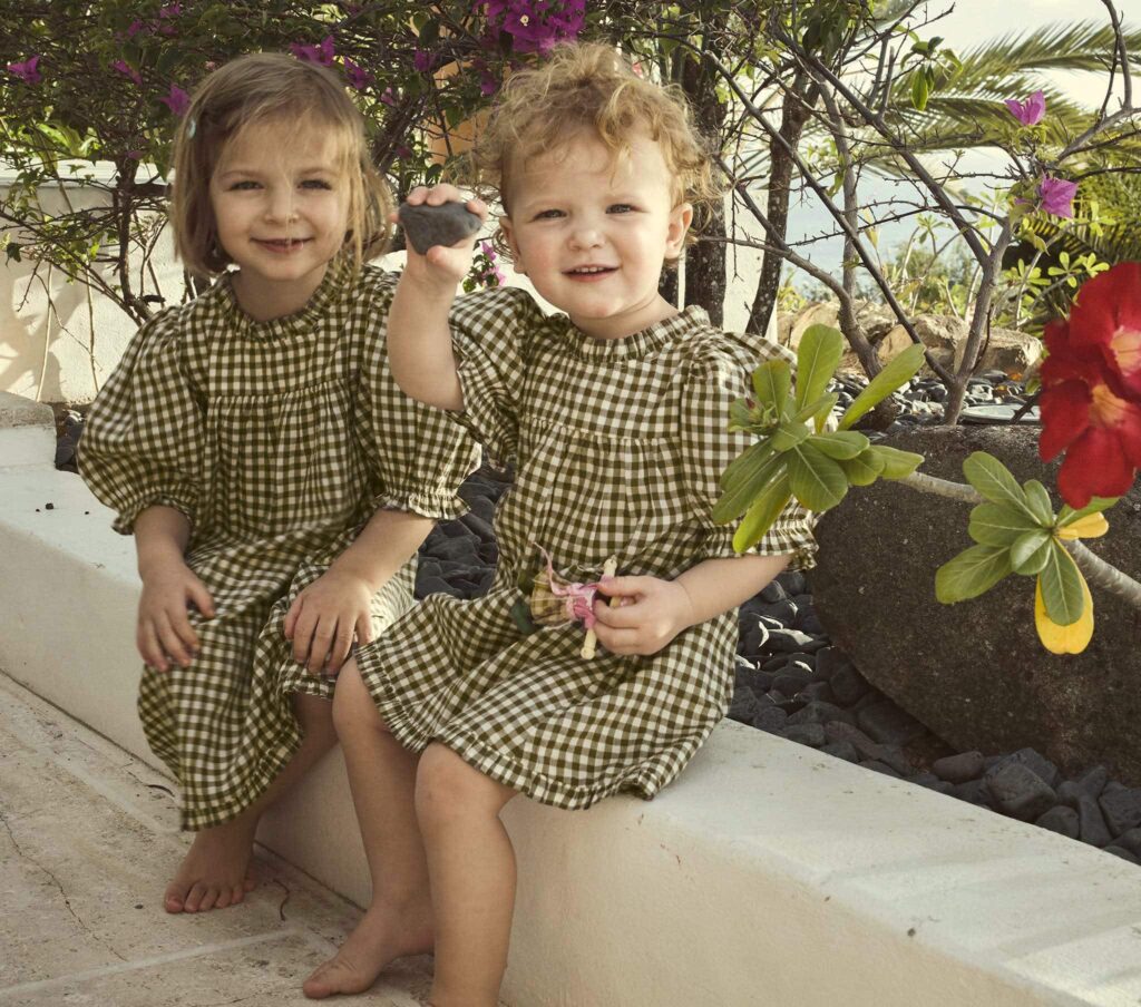 Little girls in matching olive gingham dresses from Doen