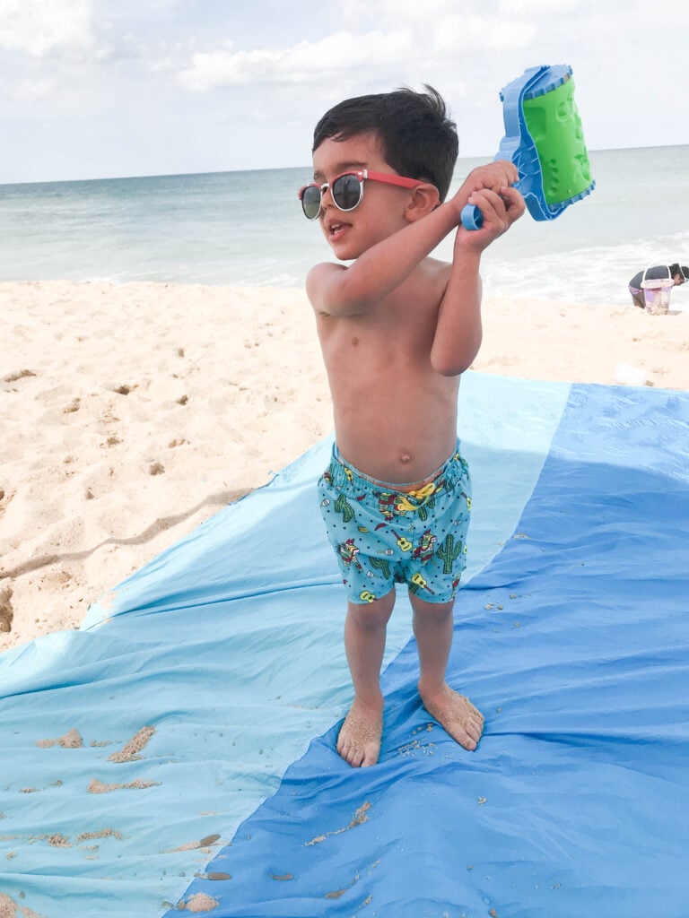 toddler on the beach on beach blanket