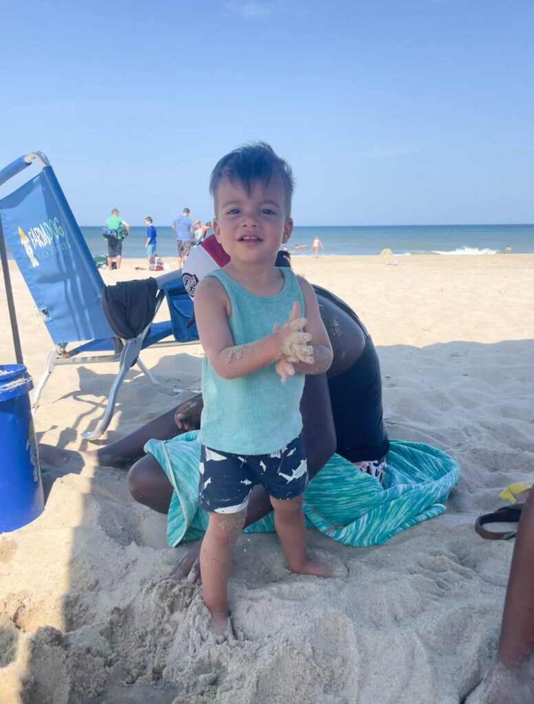 baby playing in sand at the beach