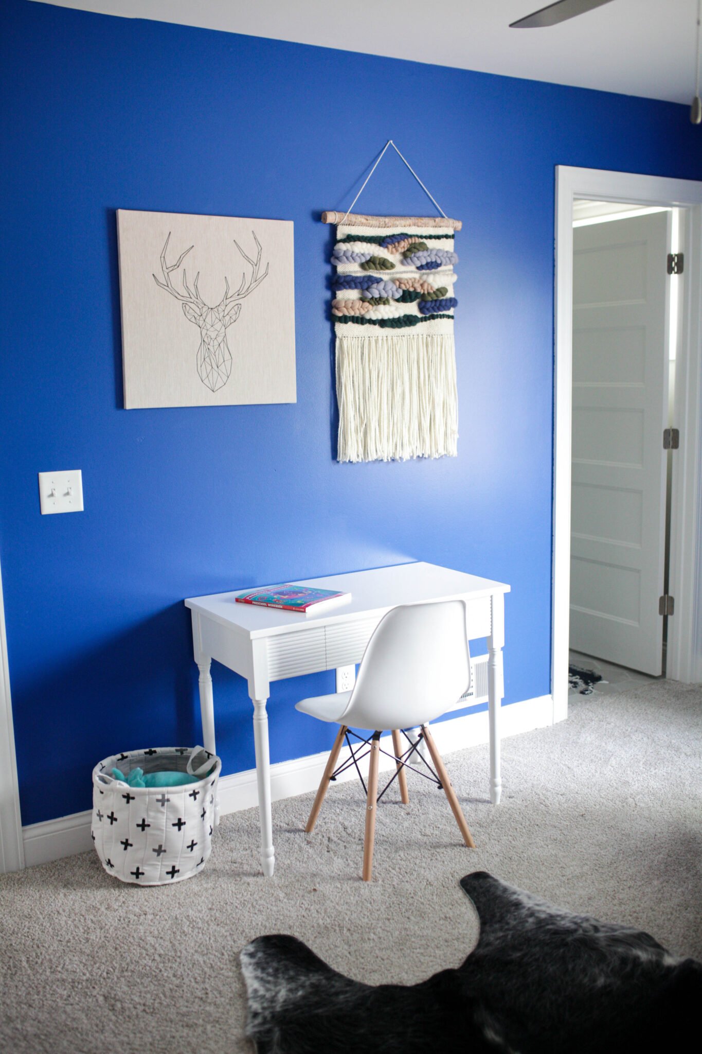 Desk and wall hanging with bright blue boys bedroom