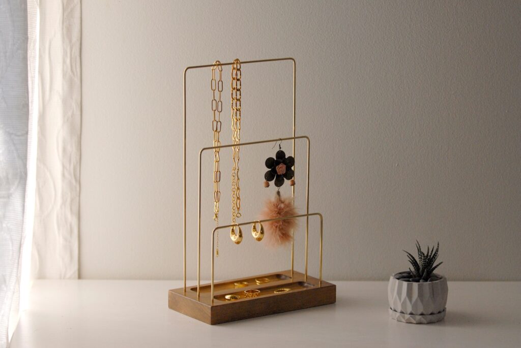 Jewelry hanging on jewelry stand with wood base and 3 brass bars