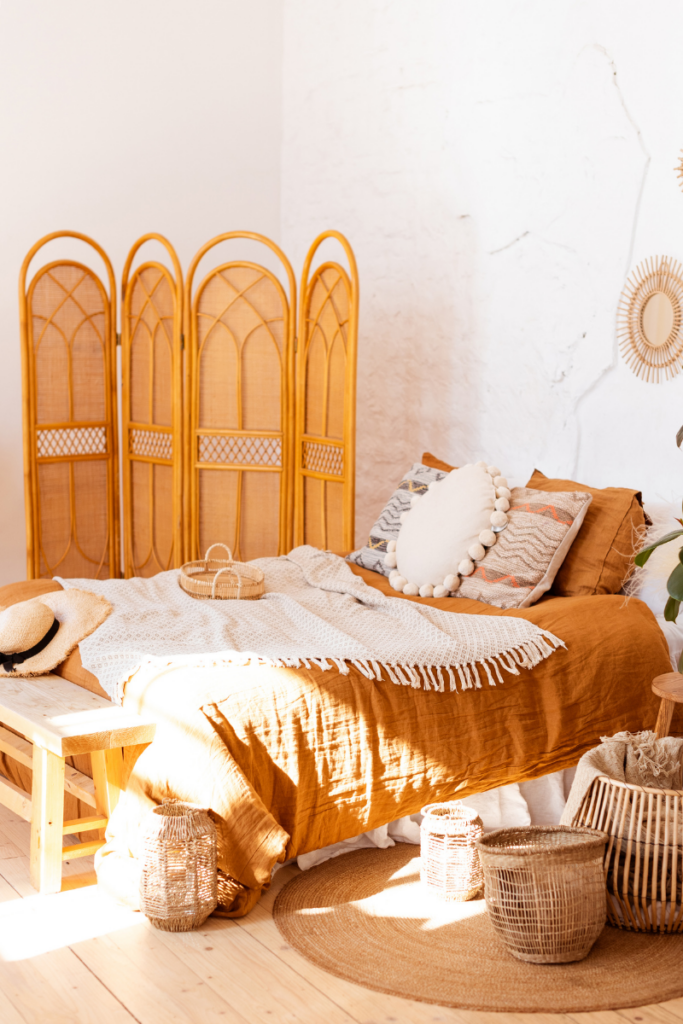 Boho bedroom with orange bedding and screen