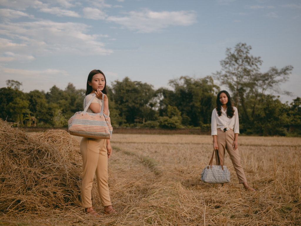 JOYN - two women standing in a field holding weekender bags