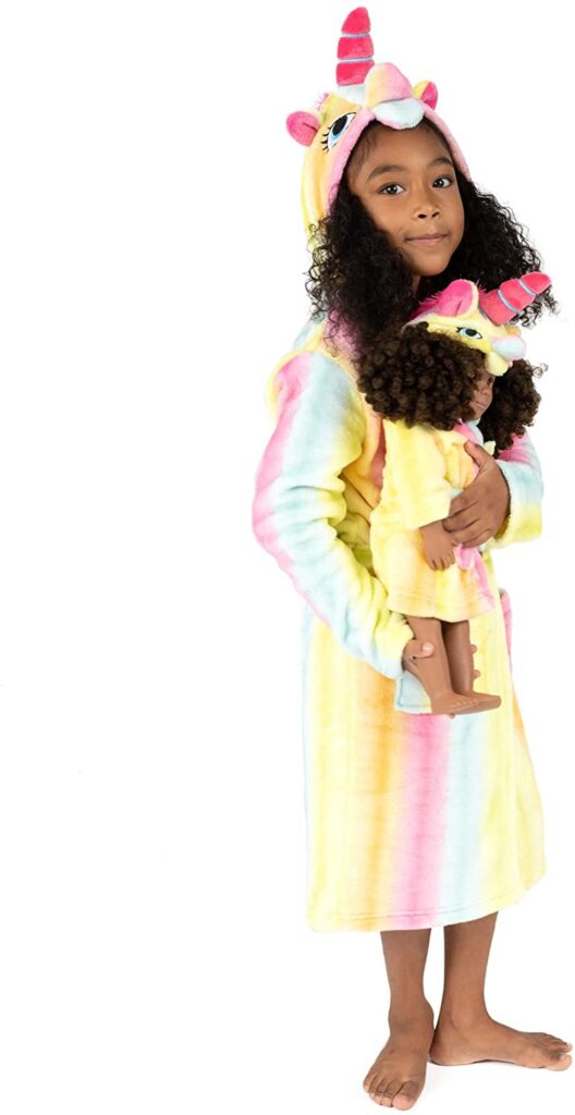 Girl in unicorn robe with doll with matching robe