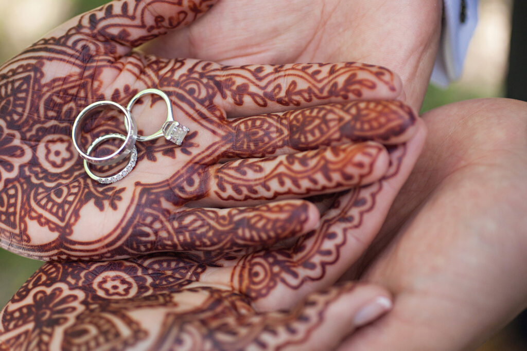 Engagement ring and wedding band in hand with henna