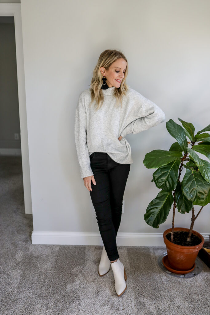 Person wearing white leather chelsea booties and black pants photo